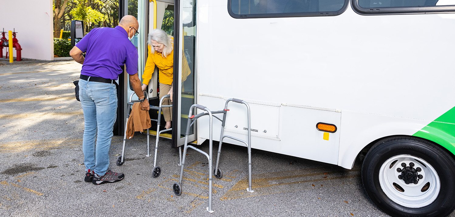 Bus driver helping participant off bus