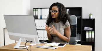 African-american female sitting at desk on video call