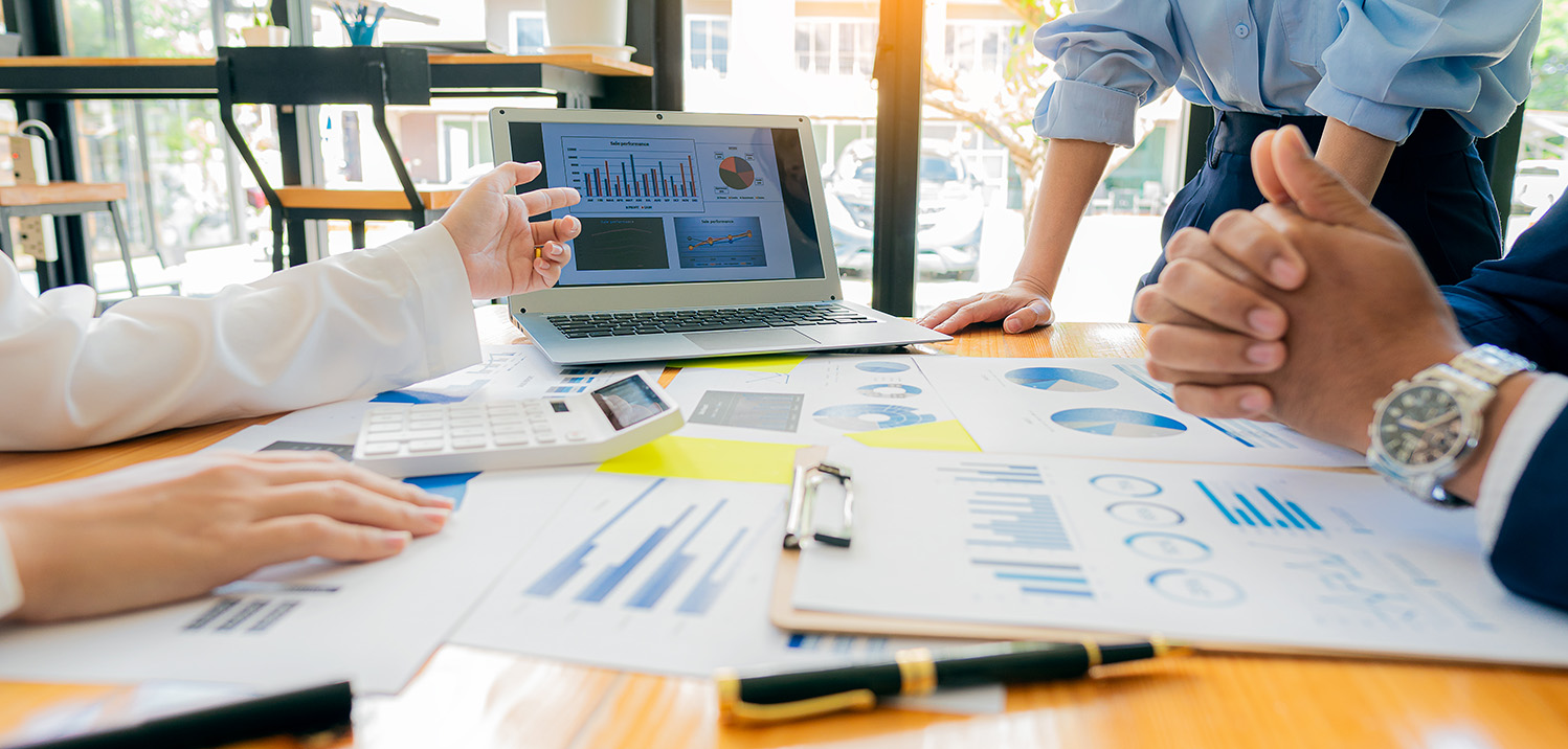 group of people at table discussing financials in office