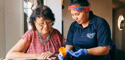 home aide reviewing and sorting meds with participant at home