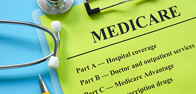 green medicare info on clipboard with stethoscope laying on top