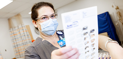 Nurse examining pill packet in clinic