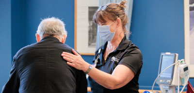 PT with participant at Johns Hopkins hand on back