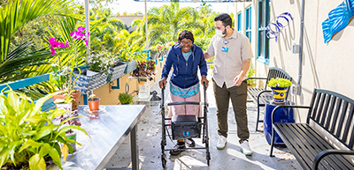 Recreation therapist walking in garden with participant