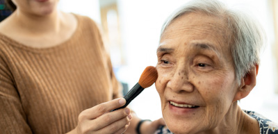 Una adulta mayor siendo maquillada