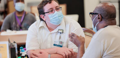 Social worker and participant talking at table at Johns Hopkins ElderPlace