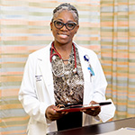 Smiling Medical director holding clipboard in clinic